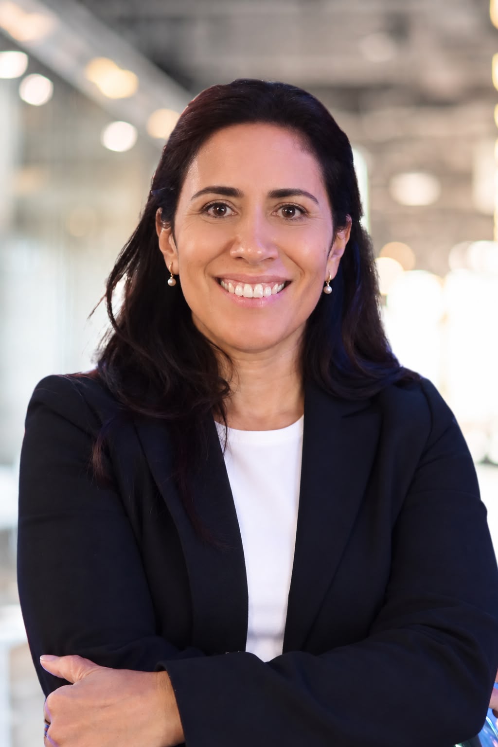 Margarita Colombo, smiling, in a navy blazer.