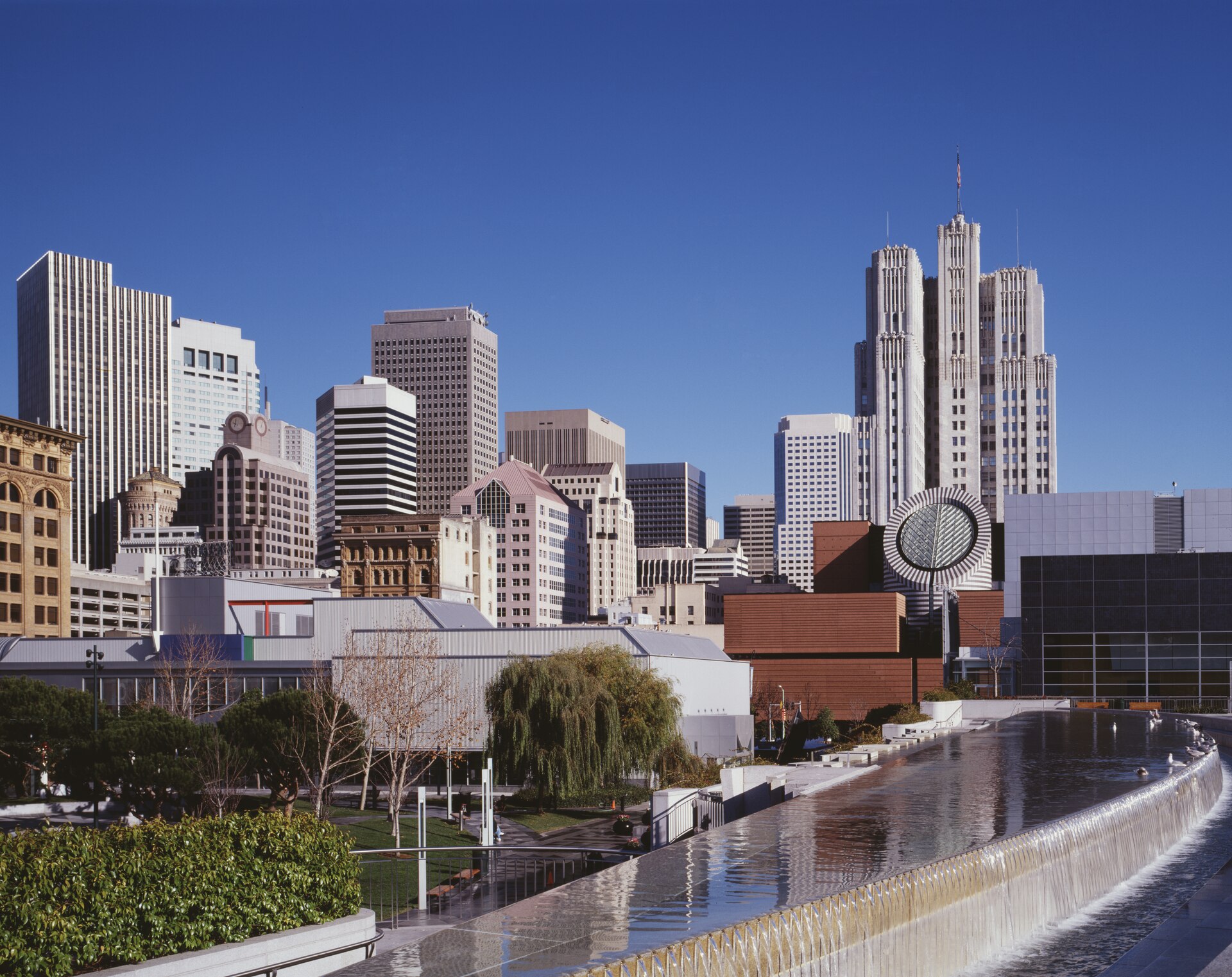 Historic view of Moscone Center among downtown San Francisco buildings.